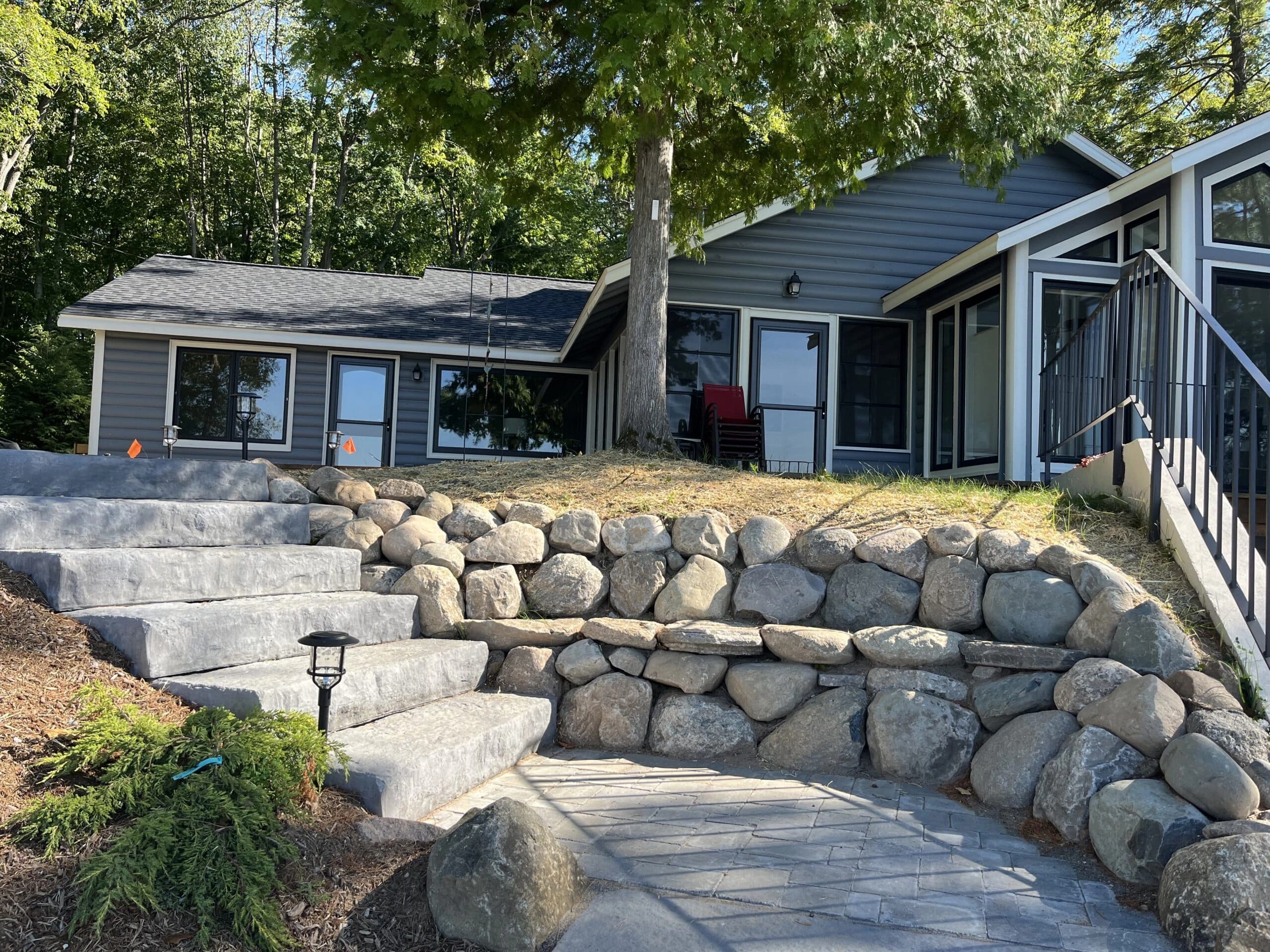 Natural boulder retaining wall on a steep lakefront slope