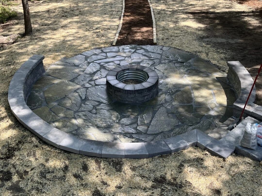 Circular flagstone patio with fire pit at lakefront property