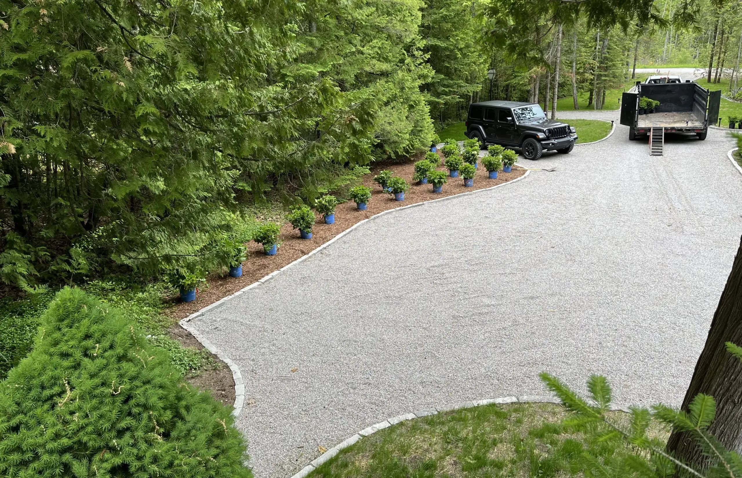 Finished gravel driveway with stone edging and plantings